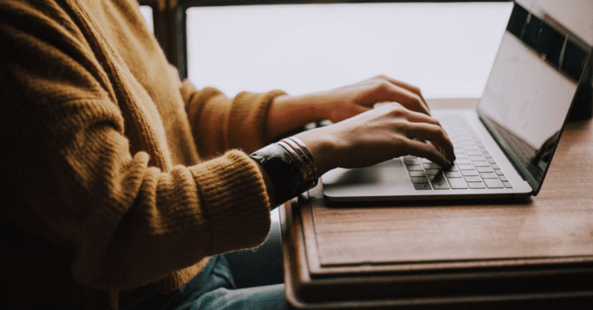 Person typing on a laptop at desk.