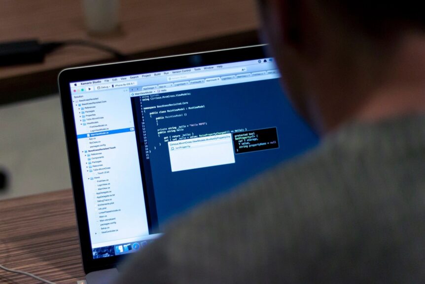 Person coding on a laptop in office.