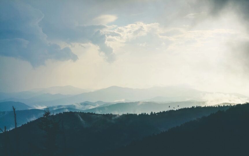 Misty mountain landscape under cloudy sky.