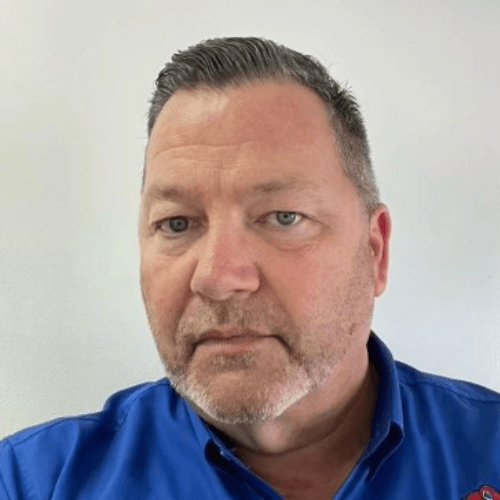 Man in blue shirt, neutral expression.