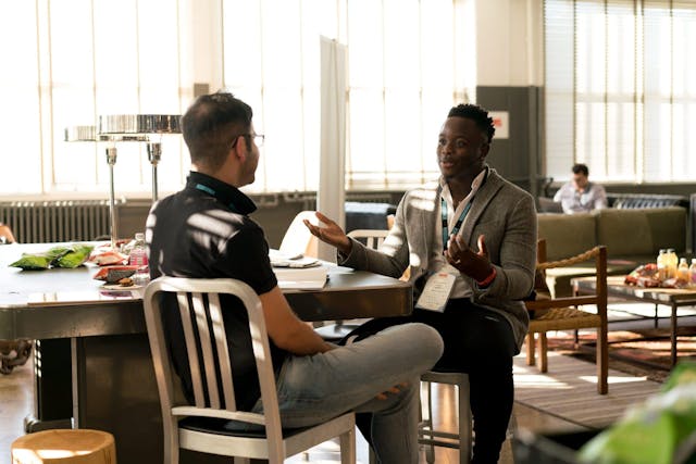 Two people talking at a table.